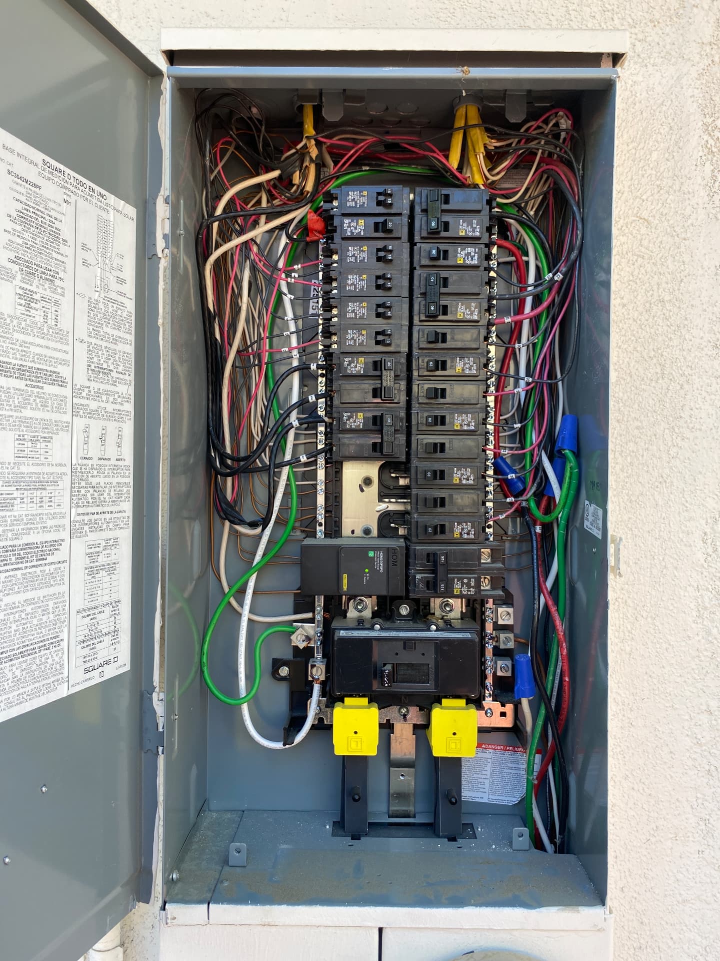 Open electrical service panel with breakers and branch circuit wiring exposed during an inspection