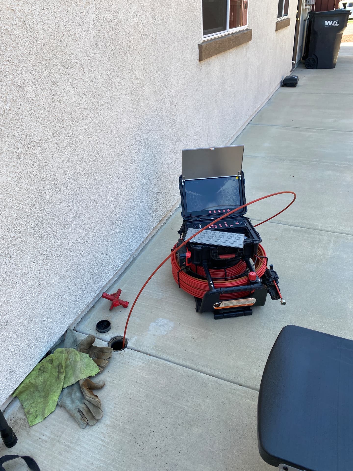 Sewer scope camera reel and monitor set up at a cleanout on a residential side yard